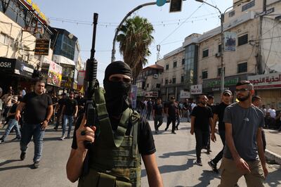 Gunmen attend the funeral of Al Aqsa Brigades members reportedly killed in an Israeli raid in Jenin. AFP