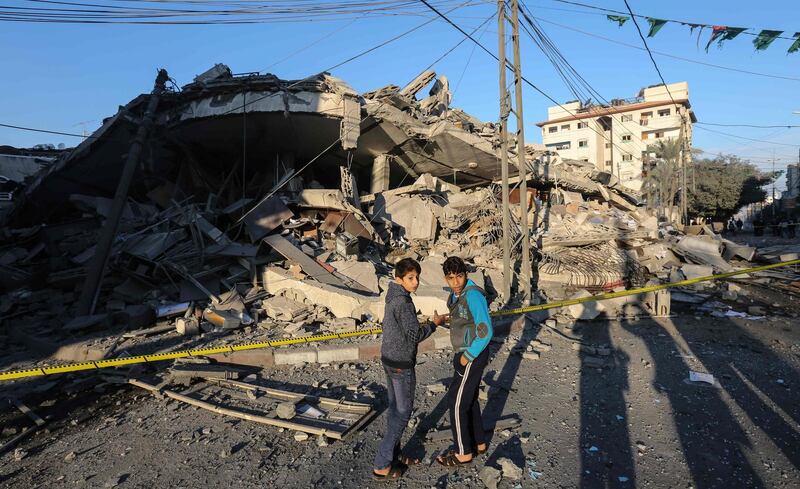 Palestinian children stand in front of a damaged building in Gaza City. AFP Photo