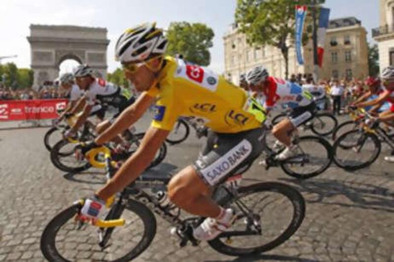 The Tour de France winner Carlos Sastre of Spain wears the leader's yellow jersey as he cycles past the Arc de Triomph on the Champs-Elysees.