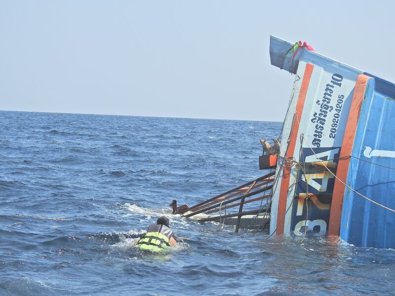 A Thai navy officer swims towards cats standing on a sinking boat to rescue them in the Andaman Sea March 2, 2021 in this picture obtained from social media. PO1 WICHIT PUKDEELON via REUTERS THIS IMAGE HAS BEEN SUPPLIED BY A THIRD PARTY. MANDATORY CREDIT. NO RESALES. NO ARCHIVES.