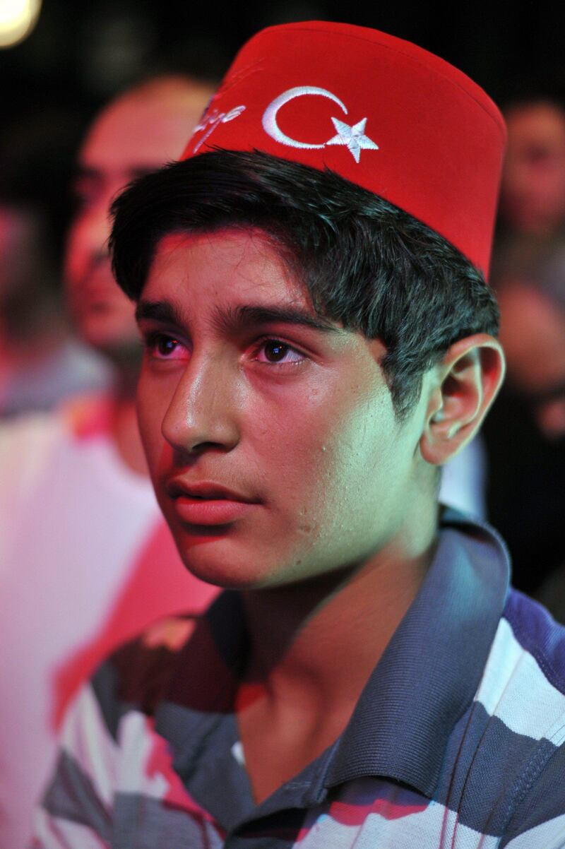 A Turkish man wearing a traditional fez reacts after IOC president announced the Japanese capital to be the winner of the bid to host the 2020 Summer Olympic Games on September 7, 2013 at Sultanahmet Square in Istanbul. The three cities bidding to host the 2020 Summer Olympics -- Madrid, Istanbul and Tokyo -- delivered their final presentations ahead of the expected tight vote by the IOC, though Madrid was eliminated from the race moments after, in the first round of voting.    AFP PHOTO / OZAN KOSE
 *** Local Caption ***  892417-01-08.jpg