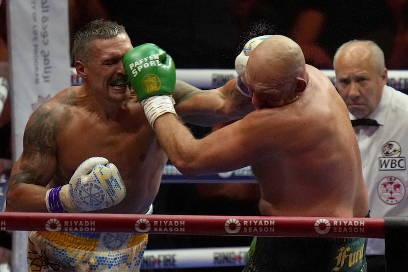 Tyson Fury and Oleksandr Usyk both land punches during their undisputed world title fight. AP