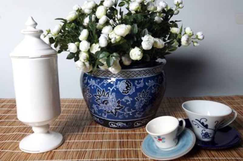 Blue pot Dh855 at Sia, flowers Dh145 at Sia, large cup Dh59 at Crate & Barrel, dark blue saucer Dh39 at Crate & Barrel, Jar Dh415 at Flamant, small cup and saucer Dh145 at Flamant.