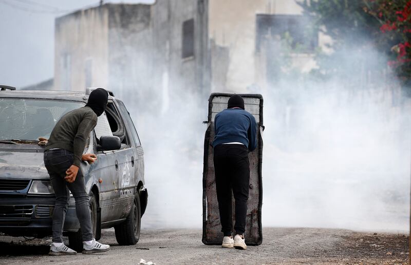 Palestinian protesters take cover after a demonstration against Israeli settlements in the West Bank. EPA