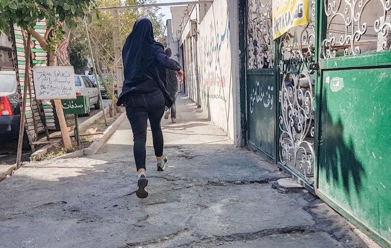 Iranian protesters run after clashing with with police. EPA