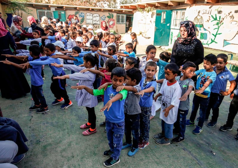 Palestinian children stand in line ahead of classes in the Bedouin village of Khan Al Ahmar in the occupied West Bank. Abbas Momani / AFP