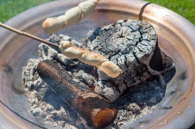 M39CY9 Bread baking over open fire - Snobrod. mwennerwald / Alamy Stock Photo