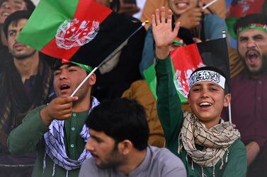 Spectators wearing Afghan and Taliban head ribbons watch the Twenty20 cricket trial match being played between two Afghan teams 'Peace Defenders' and 'Peace Heroes' at the Kabul International Cricket Stadium in Kabul on September 3, 2021.  (Photo by Aamir QURESHI  /  AFP)