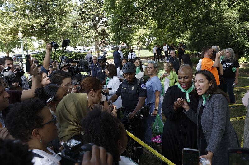 Ayanna Pressley and Ms Ocasio-Cortez speak to reporters after being arrested. AFP