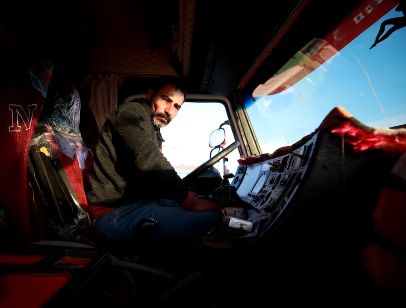 Abubaker in the cab of his lorry waits to take aid supplies to Gaza across the Rafah border. Victor Besa / The National