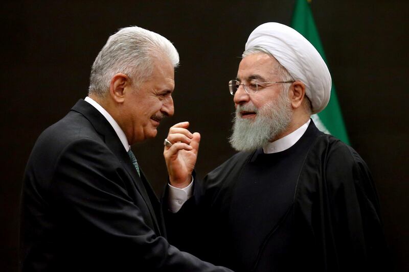 Iran's President Hassan Rouhani, right, welcomes Turkey's parliament speaker and former Prime Minister, Binali Yildirim, for their meeting, after a six-nation conference on fighting terrorism in Tehran, Iran, Saturday, Dec. 8, 2018. Rouhani on Saturday warned Western countries that they will face a massive influx of drugs if Iran becomes weakened by U.S. sanctions. (AP Photo/Ebrahim Noroozi)