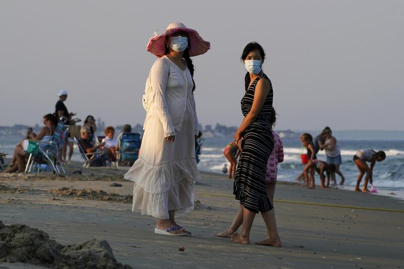 Women wear masks to help prevent the spread of coronavirus at the end of a beach day in Ogunquit, Maine, US. AP Photo