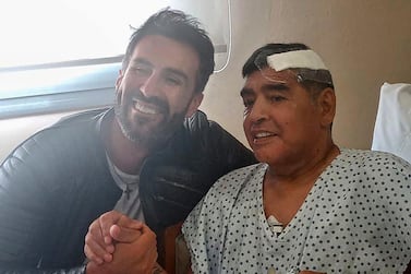 Argentine football legend Diego Maradona shaking hands with his doctor Leopoldo Luque in Olivos, Buenos Aires, shortly before leaving hospital after brain surgery. AFP