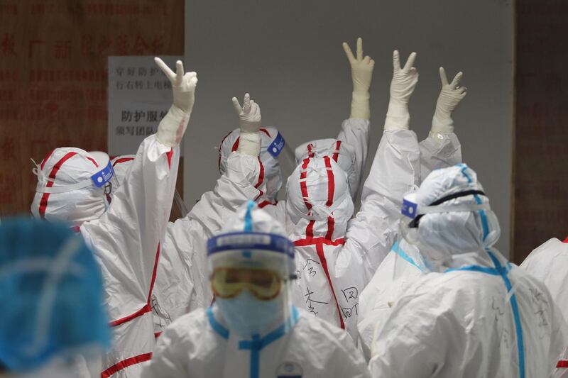 Medical staff cheer themselves up before going into an ICU ward for COVID-19 coronavirus patients at the Red Cross Hospital in Wuhan in China's central Hubei province. AFP