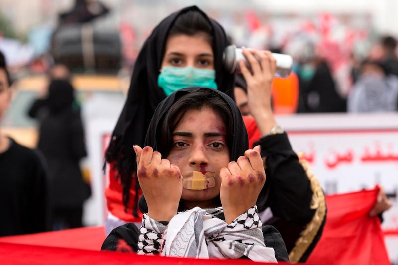 TOPSHOT - An Iraqi demonstrator with make-up to represent violence takes part in an anti-government march in the center of the southern city of Basra on December 2, 2019. Iraq's rival parties were negotiating the contours of a new government today, after the previous cabinet was brought down by a two-month protest movement demanding more deep-rooted change. / AFP / Hussein FALEH

