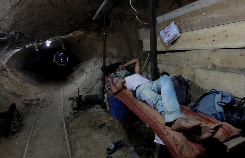 A Palestinian worker rests inside a smuggling tunnel in Rafah, on the border between Egypt and the southern Gaza Strip. Egypt’s military has tried to destroy or seal off most of them. Hatem Moussa / AP