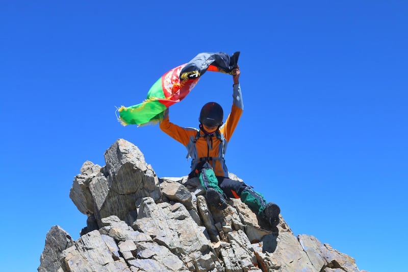Zabih Afzali holding the Afghanistan flag having submitted Mount Shah Fuladi, June 2020. Courtesy Zabih Afzali