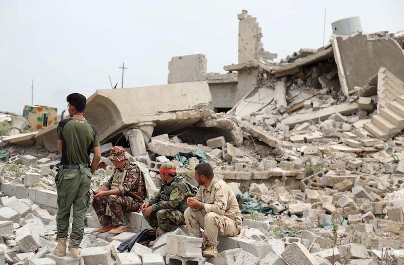 Iraqi Kurdish and Turkmen Shiite forces sit in the northern Iraqi town of Bashir after they recaptured the town from the Islamic State (IS) group on May 1, 2016. - Pressure for an operation to retake the town had grown in March after IS launched a chemical attack from Bashir on the nearby town of Taza that killed at least three children. (Photo by Mohammed SAWAF / AFP)