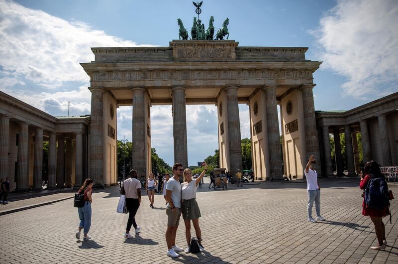 BERLIN, GERMANY - JUNE 19: Tourists stand at Brandenburg Gate during the novel coronavirus pandemic on June 19, 2020 in Berlin, Germany. Travel restrictions originally imposed to stem the spread of the virus have mostly been lifted across the European Union and businesses dependent on tourism are anxiously waiting for tourists to return in large numbers. (Photo by Maja Hitij/Getty Images)