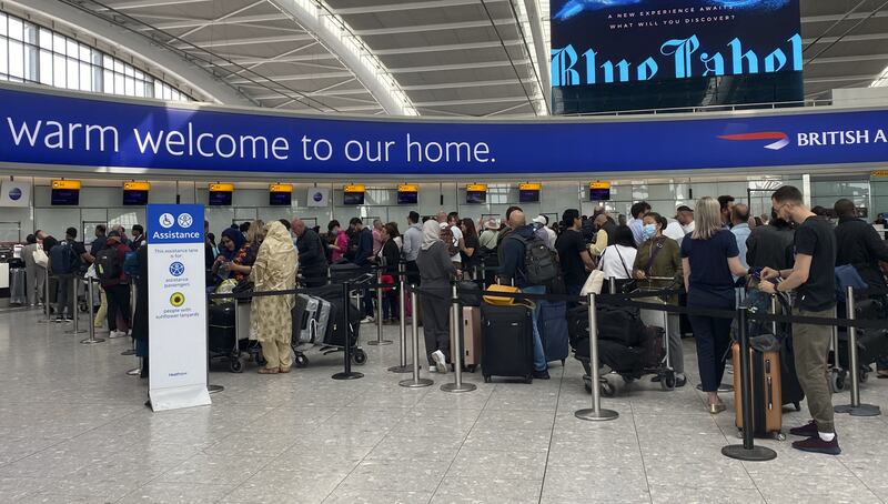 Passengers queue to check-in for a Qatar Airways flight in Terminal 5 at London's Heathrow Airport as travellers are told to expect chaos. PA