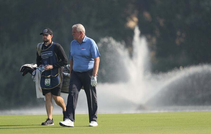 Colin Montgomerie of Scotland and his caddie walk on a fairway.