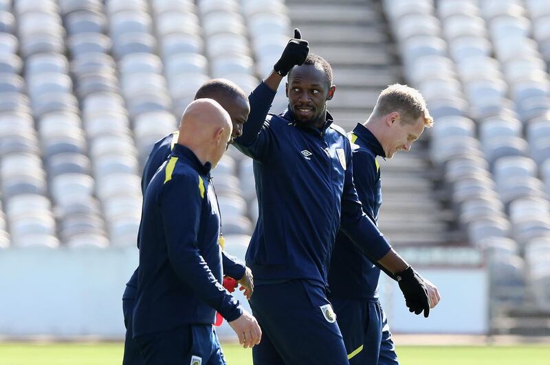 Usain Bolt gives a thumbs up during a warm up for the training session. Getty Images