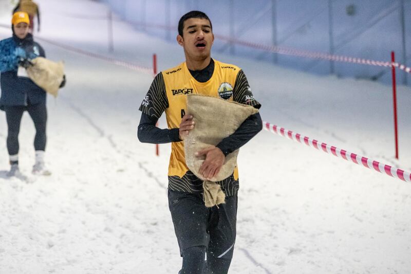 Competitors carried sand bags through the snow.

