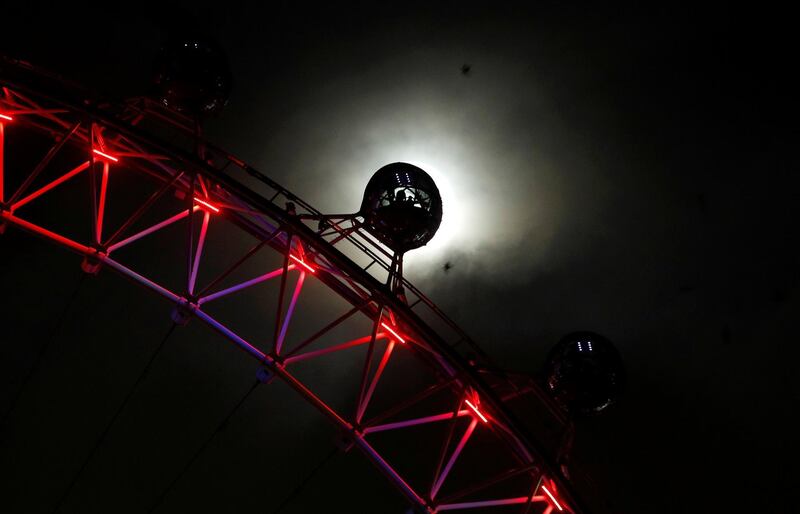 The moon rises behind a pod on the London Eye, lit in red for World AIDS Day, in London. Peter Nicholls / Reuters