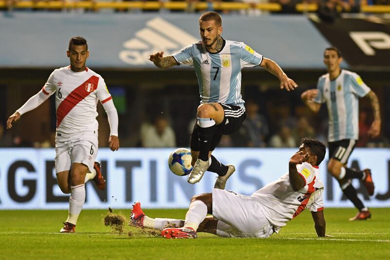 Argentina's Dario Benedetto jumps over Peru's Miguel Araujo during their 2018 World Cup qualifier football match in Buenos Aires on October 5, 2017. / AFP PHOTO / Eitan ABRAMOVICH