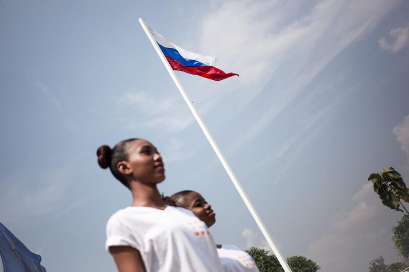 The Russian flag overlooks the Miss Central African Republic 2018 contestants during a shooting before the beauty pageant, at Bangui National Stadium, on December 9, 2018.   The Miss Central African Republic beauty pageant has disappeared from the country since 2015, and resurrected thanks to Russia, already present through military donations. / AFP / FLORENT VERGNES
