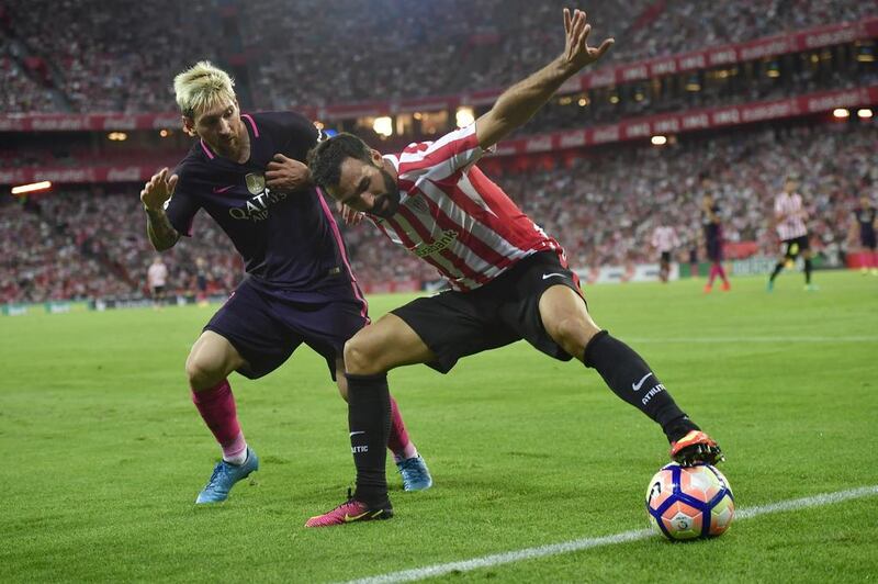 Barcelona’s Lionel Messi, left, duels for the ball with Athletic Bilbao’s Mikel Balenziaga. Alvaro Barrientos / AP Photo