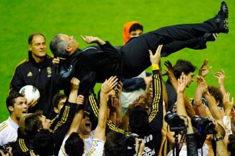 Real Madrid players celebrate their Primera Liga title win with manager Jose Mourinho last night.