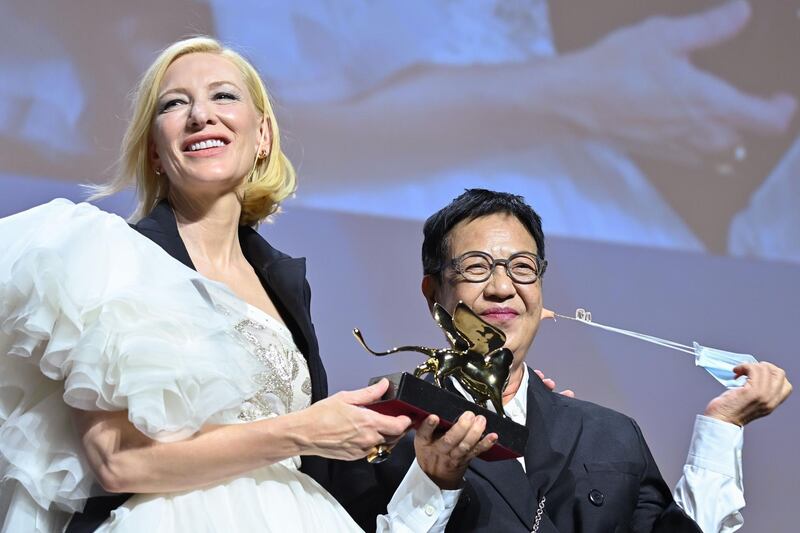 Hong-Kong director Ann Hui, right, takes off her face mask as she receives a Golden Lion award for Lifetime Achievement from from Australian-US actress Cate Blanchett, the Jury President of the 77th Venice Film festival. AFP