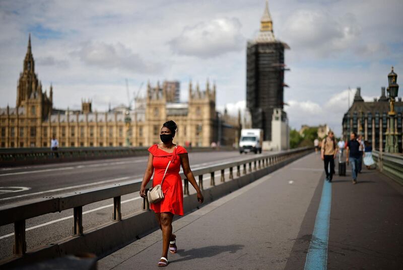 A pedestrian wearing a face covering walks over Westminster Bridge near the Houses of Parliament in central London. The Delta variant of the coronavirus is estimated to be 40% more transmissible than the variant that caused the last wave of infections in the UK, Britain's health minister said Sunday. AFP