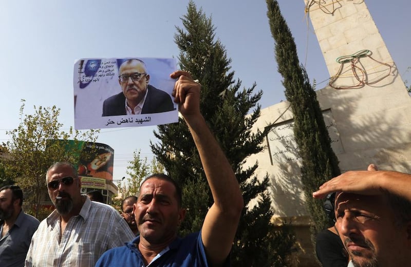 A man holds up a photo of Nahed Hattar, who was shot dead earlier in the day, in his family's hometown of Fuheis on September 25 2016. Hattar. Jamal Nasrallah/EPA