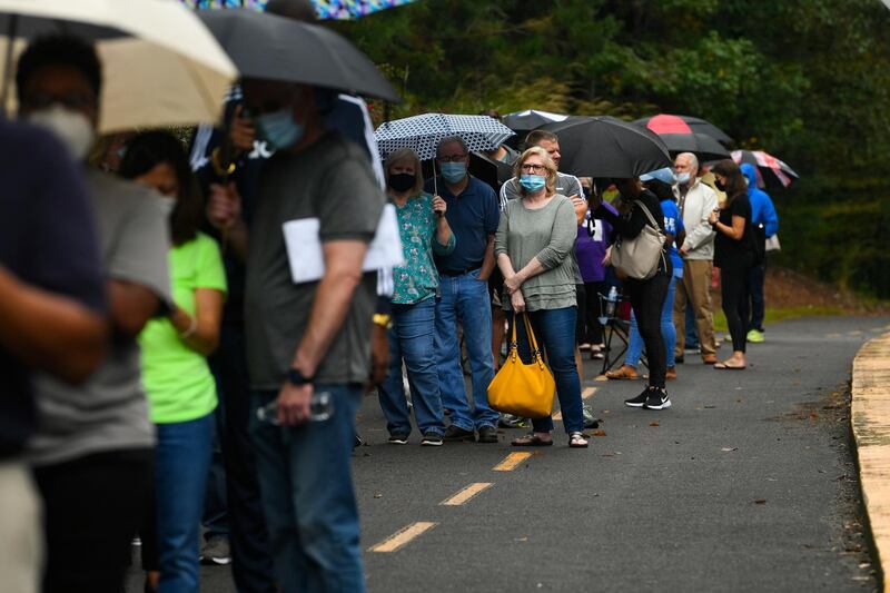 Voters wait in a line to vote that has an estimated 3-hour as the first day of early voting is underway at the George Pierce Park in Suwanee, Georgia, USA.  EPA