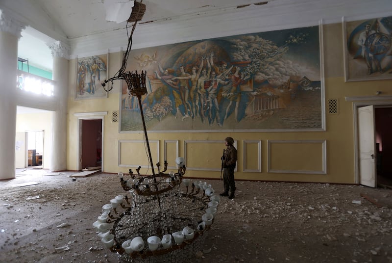 A Ukrainian serviceman surveys the damaged cultural centre, in the town of Rubizhne, Luhansk region.  AFP