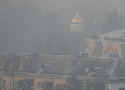 A church and buildings covered with smoke from forest fires raging in the 30 km (19 miles) exclusion zone around the Chernobyl nuclear power plant and elsewhere in the country are seen in Kiev, Ukraine April 17, 2020.  REUTERS/Gleb Garanich