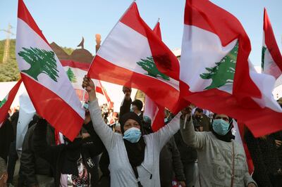 Muslims women wave Lebanese flags as Maronite Patriarch Bechara Rai speaks during a rally at the church's seat in Bkirki, northeast of Beirut, Lebanon, Saturday, Feb. 27, 2021. Thousands of people participated Saturday in a rally held in Bkerki, the headquarters of the Maronite Catholic church to express their support to Cardinal Bechara Rai's calls for Lebanon to become a neutral state and for an international conference to help Lebanon get out of its political and economic crisis. (AP Photo/Bilal Hussein)