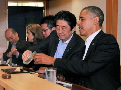 FILE PHOTO : Japanese Prime Minister Shinzo Abe pours sake for U.S. President Barack Obama as they have dinner at the Sukiyabashi Jiro sushi restaurant in Tokyo, in this picture taken April 23, 2014, and released by Japan's Cabinet Public Relations Office. Cabinet Public Relations Office/Handout via Reuters/File Photo THIS IMAGE HAS BEEN SUPPLIED BY A THIRD PARTY. MANDATORY CREDIT. JAPAN OUT.