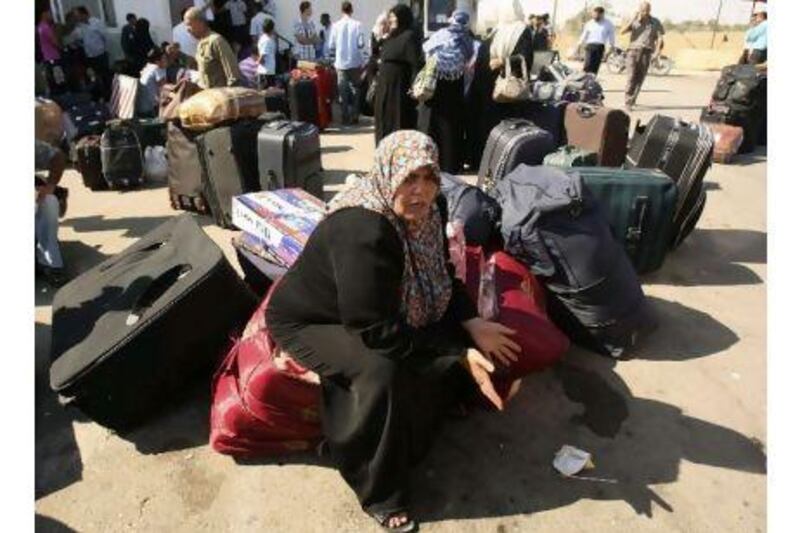 A Palestinian woman waits to cross into Egypt at the Rafah border crossing in the southern Gaza Strip yesterday. Ibraheem Abu Mustafa / Reuters