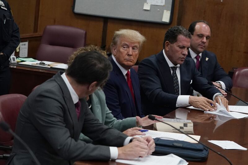 Former US President Donald Trump with his defence team during his arraignment at the court in New York. AFP