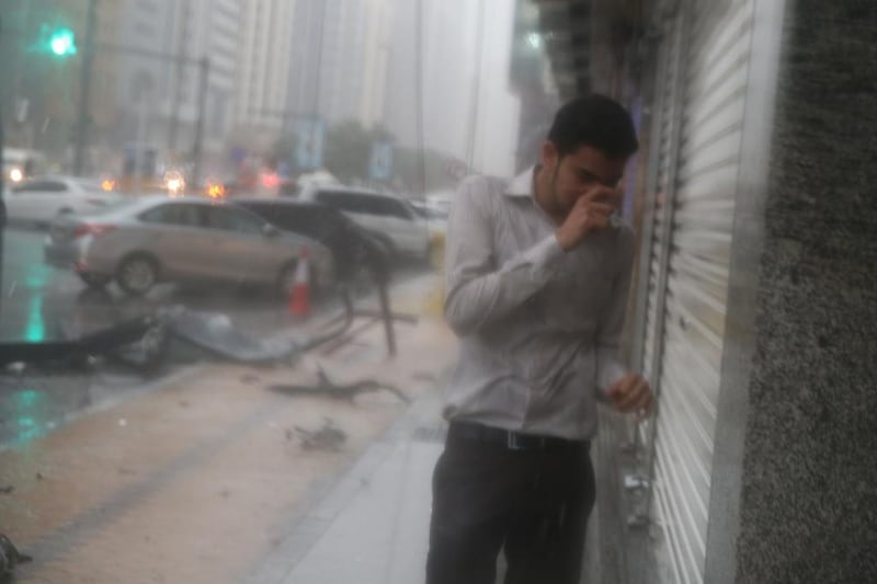 A man seeks shelter as heavy rain and strong winds hammer Abu Dhabi.  Delores Johnson / The National