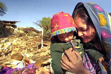 A woman clutches her daughter as she weeps in front of the ruins of her house in Bhuj, Gujarat state, in western India, on January 27, 2001. AFP 