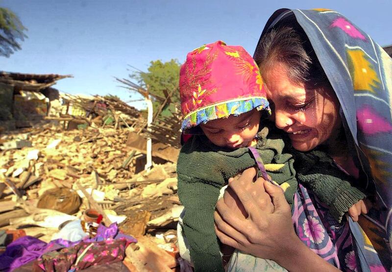 A woman clutches her daughter as she cries in front of the ruins of her house in Bound village in Bhuj district in the western Indian state of Gujarat, 27 January 2001, after an earthquake measuring 6.9 on the Richter scale struck north western India, 26 January 2001, rendering thousands homeless. At least 5000 people are feared dead as a result of the tremor, with casualties expected to rise.  AFP PHOTO/Arko DATTA (Photo by ARKO DATTA / AFP)