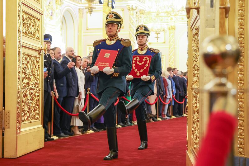Presidential regiment guards carry a gold-embossed copy of the Russian Constitution and the presidential chain of office. AP