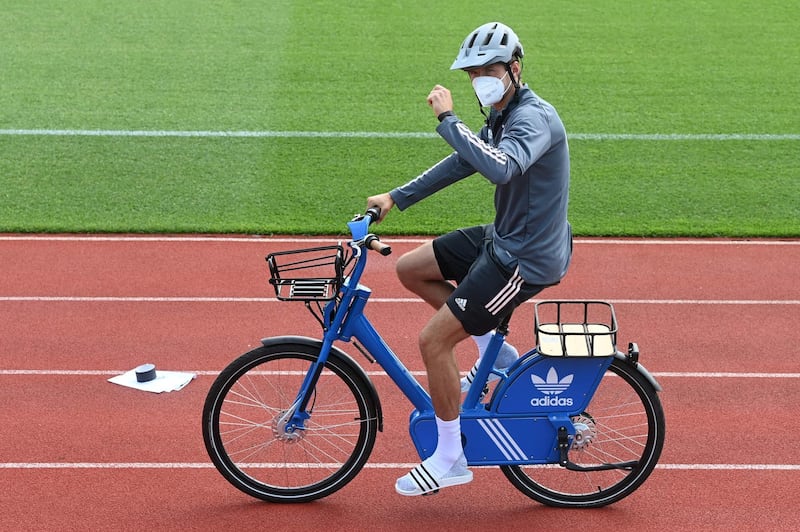 Germany forward Thomas Muller arrives on a bike. AFP