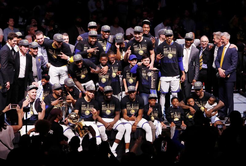 Golden State Warriors players pose for pictures with the NBA Finals trophy. David Maxwell / EPA