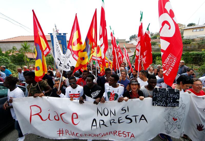 FILE PHOTO: Migrants demonstrate in support of the mayor of the town Domenico Lucano in front of his house in the southern Italian town of Riace, October 6, 2018. The banner reads: "You can't arrest Riace". REUTERS/Yara Nardi/File Photo