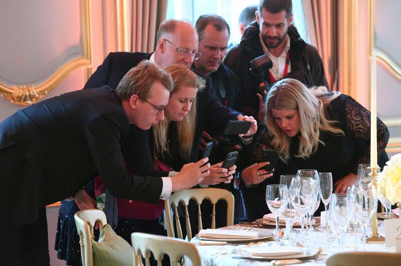 Journalists take photos of place settings for the Return Dinner at Winfield House, the residence of the Ambassador of the United States of America to the UK, in Regent's Park, London. AP